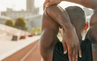 Palm Beach orthopedist assessing shoulder range of motion in a patient with frozen shoulder