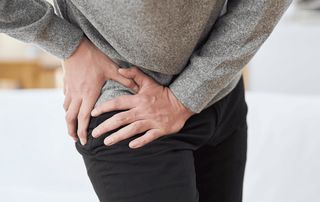 Orthopedist examining a patient's hip to distinguish hip bursitis from hip arthritis in Delray Beach