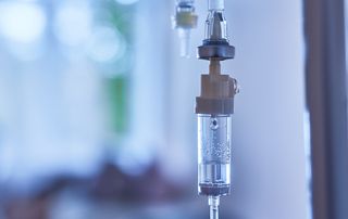 Intravenous fluid bag and line prepared for a patient being treated for dehydration in a clinical setting