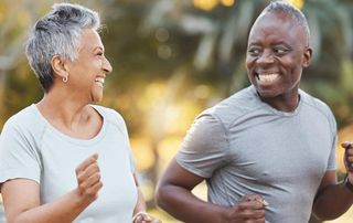 Active older couple jogging outdoors and smiling, representing Boca Raton patients staying active with PRP regenerative therapy at Tyrance Orthopedics.