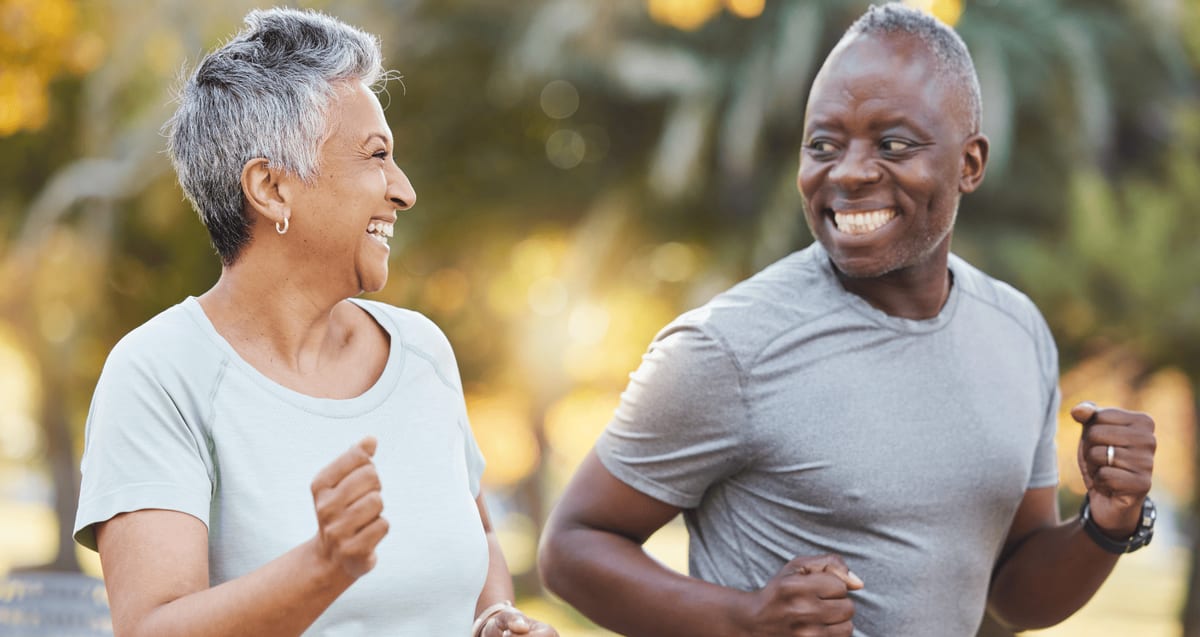 Active older couple jogging outdoors and smiling, representing Boca Raton patients staying active with PRP regenerative therapy at Tyrance Orthopedics.