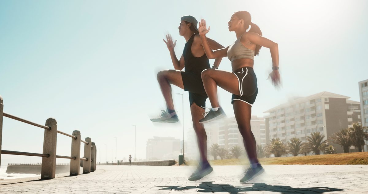 Two runners mid-stride in an outdoor plyometric drill, the kind of loading a reconstructed knee has to handle before a return to sport.