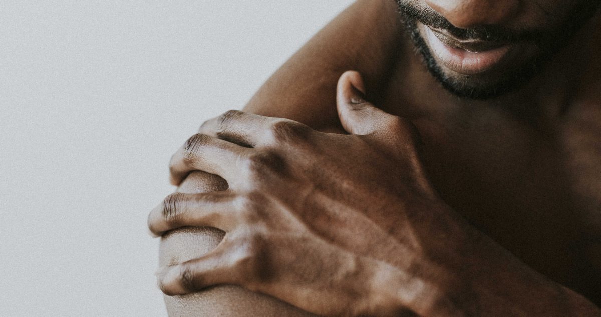 Man holding his sore outer shoulder, the area of the subacromial bursa where shoulder bursitis symptoms appear.
